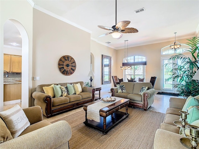 living room featuring sink, ceiling fan, crown molding, and light tile patterned flooring