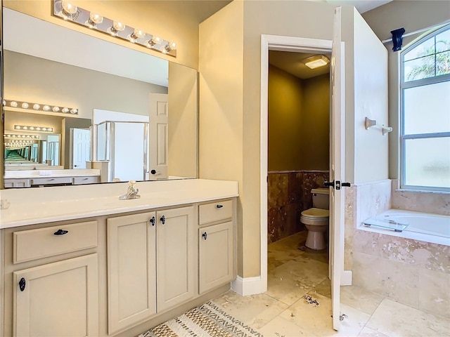 full bathroom featuring vanity, toilet, and independent shower and bath