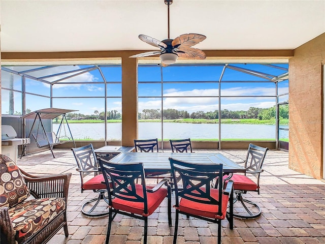 view of patio / terrace with ceiling fan, a water view, and a lanai