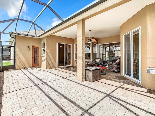 view of patio featuring ceiling fan and a lanai