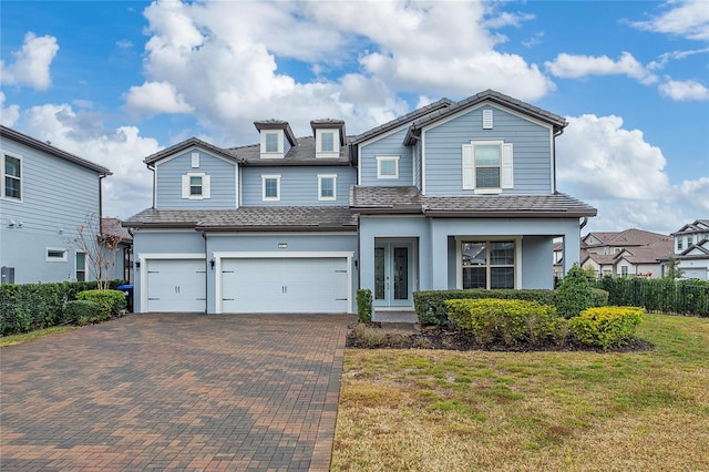 view of front of property featuring a garage, a front lawn, and french doors