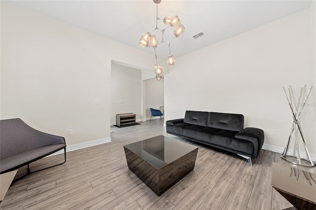 living room featuring light wood-type flooring and a chandelier