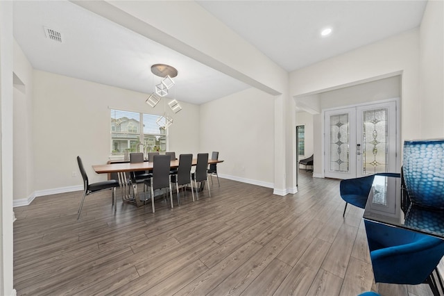 dining space with french doors and hardwood / wood-style floors