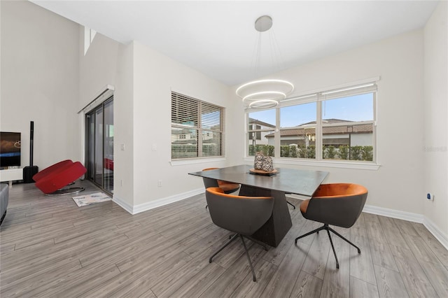 dining room with light wood-type flooring, breakfast area, and a notable chandelier