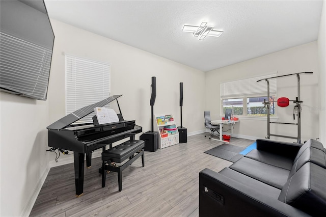 interior space featuring light wood-type flooring and a textured ceiling