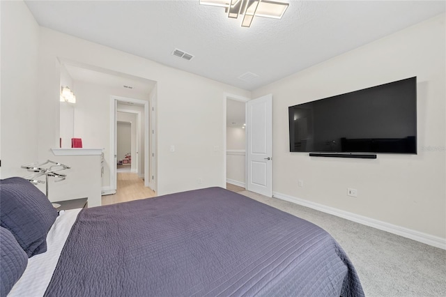 bedroom featuring light colored carpet and a textured ceiling