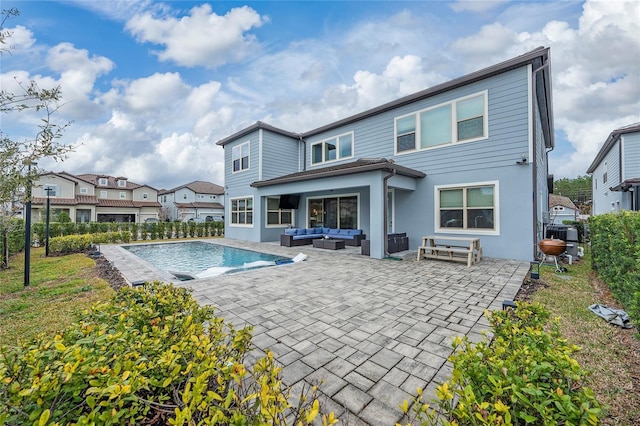 rear view of house with an outdoor living space, a fenced in pool, and a patio