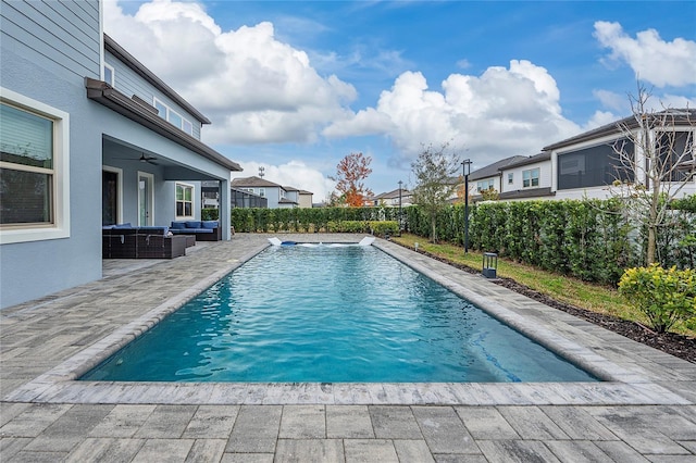 view of swimming pool with pool water feature, a patio area, outdoor lounge area, and ceiling fan