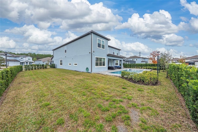 rear view of house with a fenced in pool and a yard