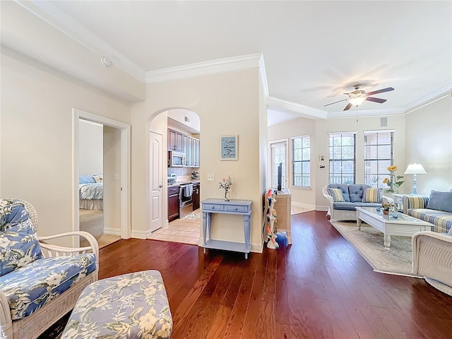 living room with ceiling fan, ornamental molding, and dark hardwood / wood-style floors