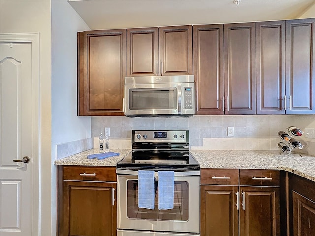 kitchen with dark brown cabinetry, appliances with stainless steel finishes, and backsplash