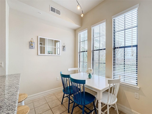 dining area with a wealth of natural light and light tile patterned flooring