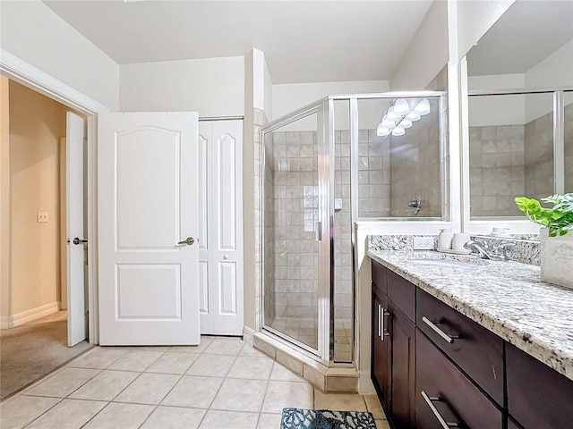 bathroom featuring vanity, a shower with door, and tile patterned flooring