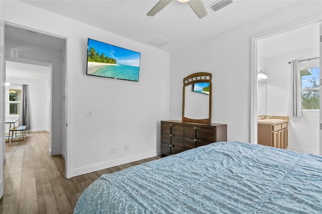 bedroom featuring connected bathroom, wood-type flooring, and ceiling fan