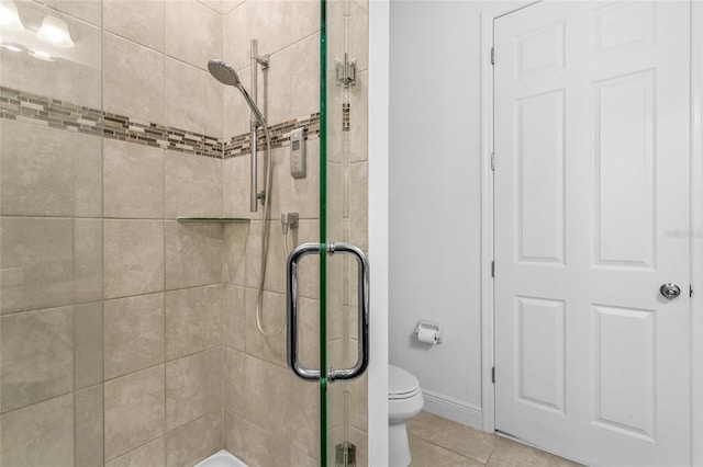 bathroom featuring tile patterned floors, toilet, and a shower with shower door