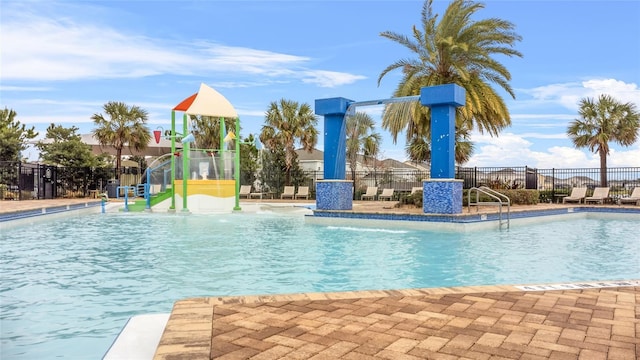 view of pool with a playground and pool water feature