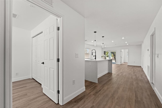 corridor with hardwood / wood-style flooring