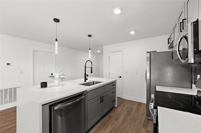 kitchen with sink, appliances with stainless steel finishes, a kitchen island with sink, gray cabinetry, and decorative light fixtures