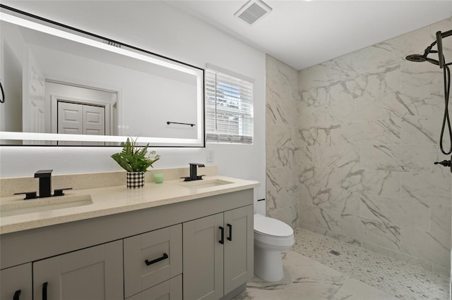 bathroom featuring vanity, toilet, and a tile shower