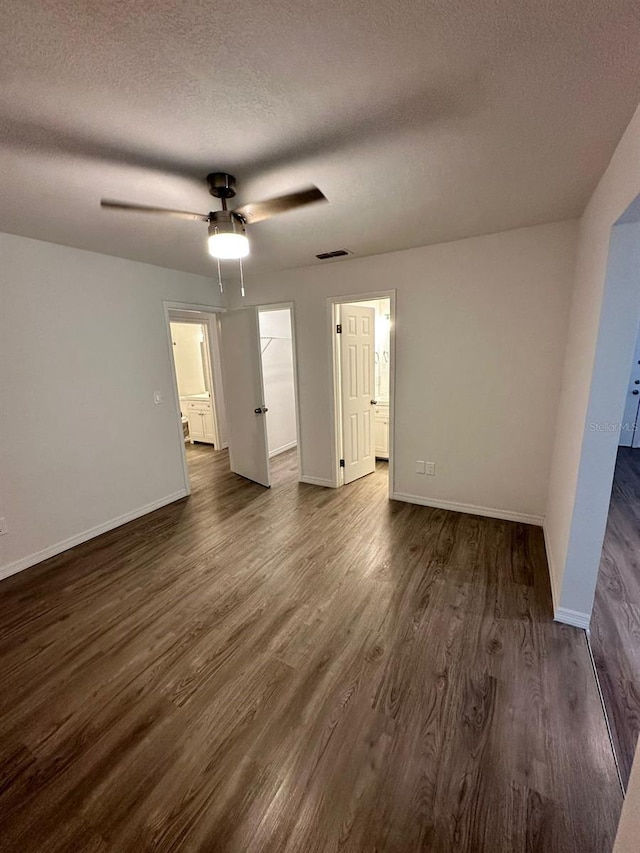 interior space featuring dark wood-type flooring, ceiling fan, and a textured ceiling