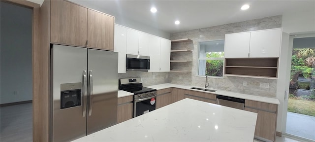 kitchen with light stone counters, sink, stainless steel appliances, and white cabinets