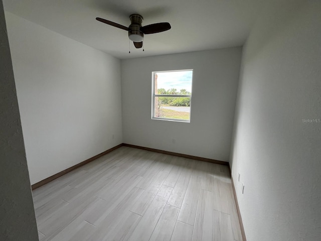 empty room with ceiling fan and light hardwood / wood-style floors