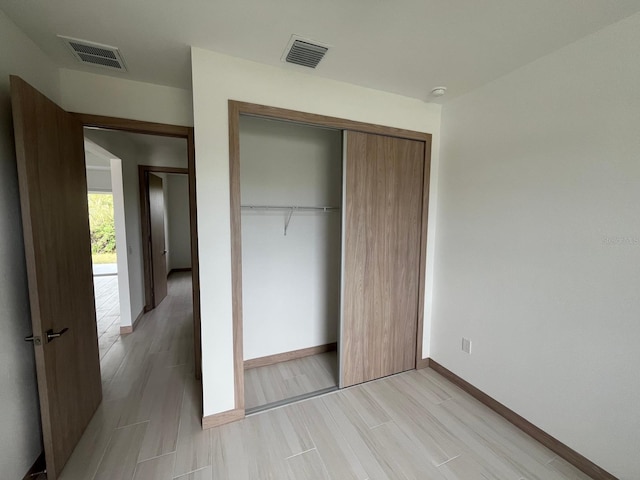 unfurnished bedroom featuring light wood-type flooring and a closet