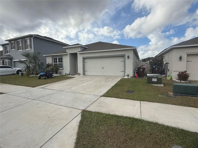 view of front of home featuring a garage, cooling unit, and a front lawn