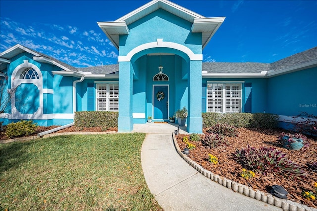 view of exterior entry with a lawn