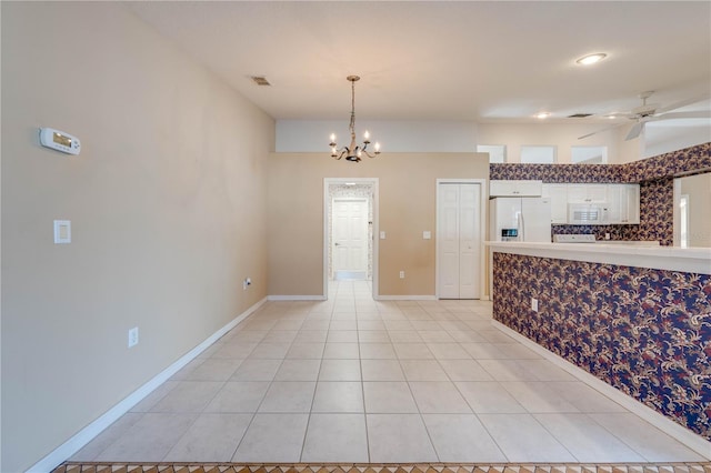 kitchen featuring white appliances, ceiling fan with notable chandelier, hanging light fixtures, and light tile patterned floors