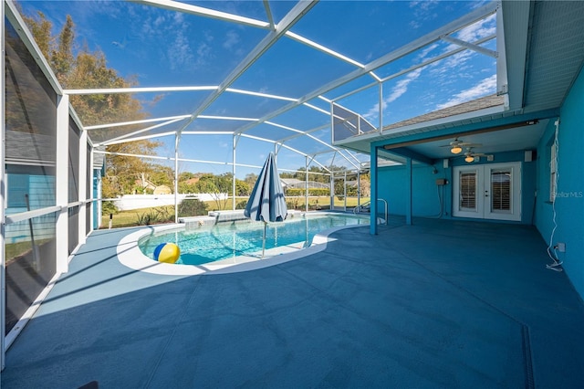 view of pool with french doors, a patio, ceiling fan, and glass enclosure