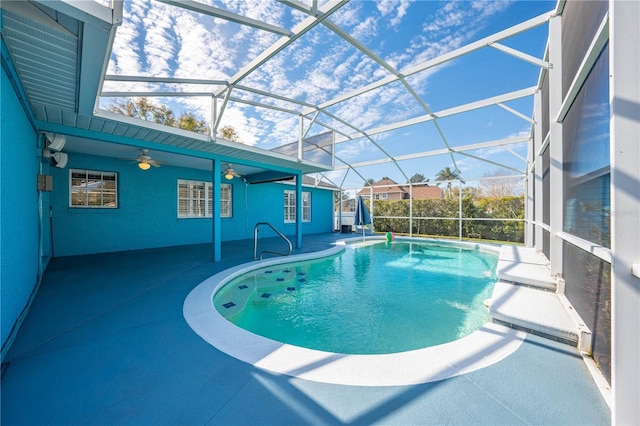 view of swimming pool with a patio area, ceiling fan, and glass enclosure