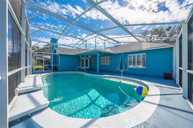 view of swimming pool featuring a lanai and a patio area