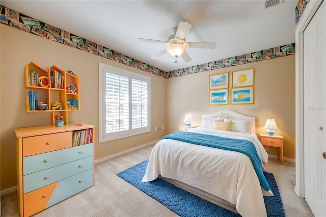 bedroom with ceiling fan, light colored carpet, and a closet