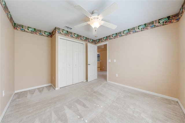 unfurnished bedroom featuring ceiling fan, light colored carpet, and a closet