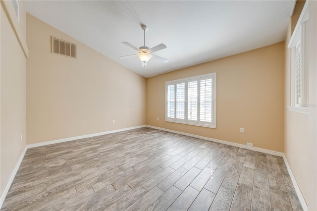 spare room featuring light hardwood / wood-style flooring, ceiling fan, and vaulted ceiling