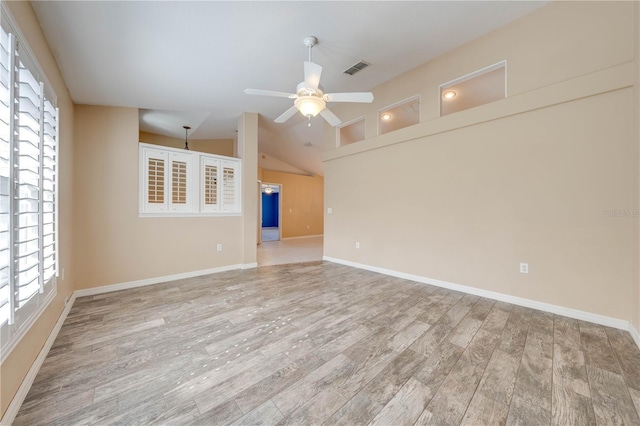 unfurnished room with ceiling fan, lofted ceiling, and light wood-type flooring