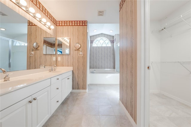 bathroom with vanity, tile patterned flooring, and plus walk in shower