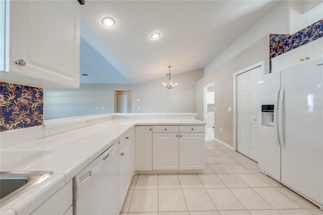 kitchen with light tile patterned flooring, white appliances, vaulted ceiling, and white cabinets