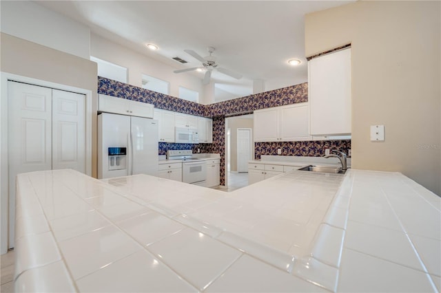 kitchen with white cabinetry, sink, backsplash, ceiling fan, and white appliances