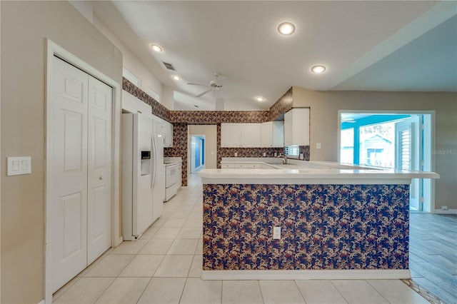 kitchen with light tile patterned floors, white appliances, ceiling fan, white cabinetry, and kitchen peninsula