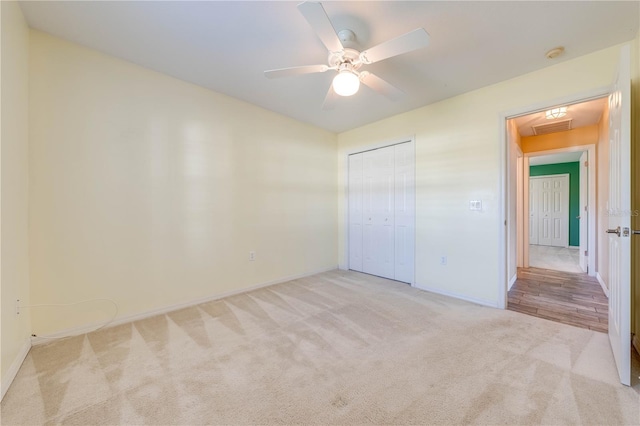 unfurnished bedroom with light colored carpet, ceiling fan, and a closet