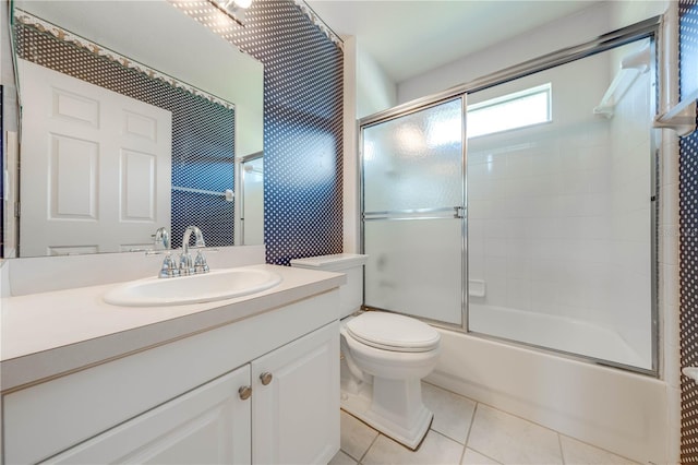 full bathroom featuring tile patterned flooring, vanity, toilet, and combined bath / shower with glass door