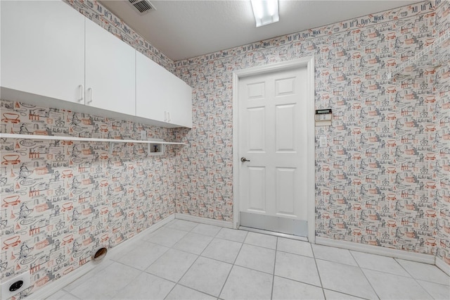 washroom featuring cabinets, light tile patterned flooring, and hookup for an electric dryer