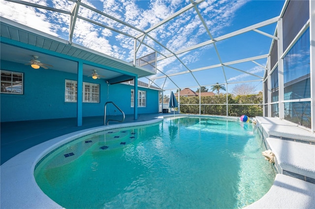 view of swimming pool with a patio, pool water feature, ceiling fan, and glass enclosure