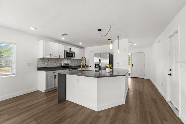 kitchen with sink, appliances with stainless steel finishes, white cabinetry, dark hardwood / wood-style floors, and decorative backsplash