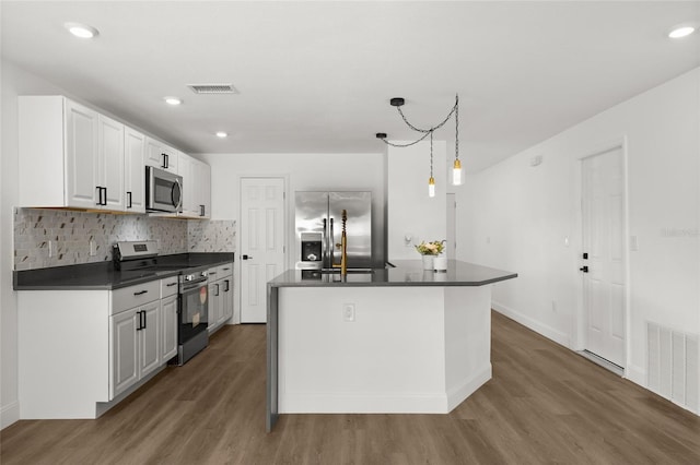 kitchen with hanging light fixtures, dark hardwood / wood-style flooring, stainless steel appliances, a kitchen island with sink, and white cabinets