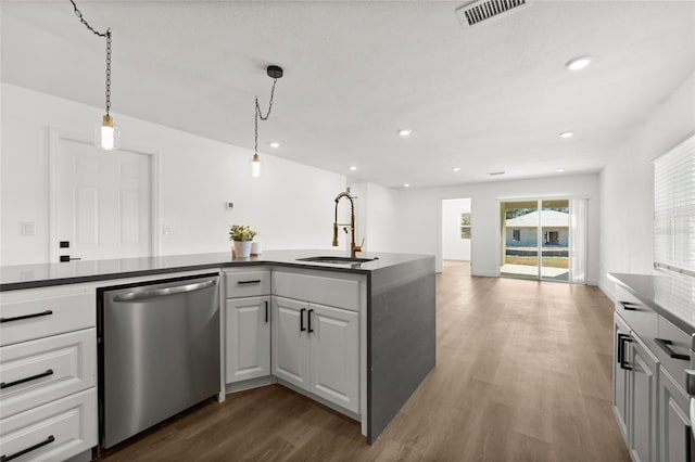 kitchen with sink, white cabinetry, decorative light fixtures, stainless steel dishwasher, and dark hardwood / wood-style flooring