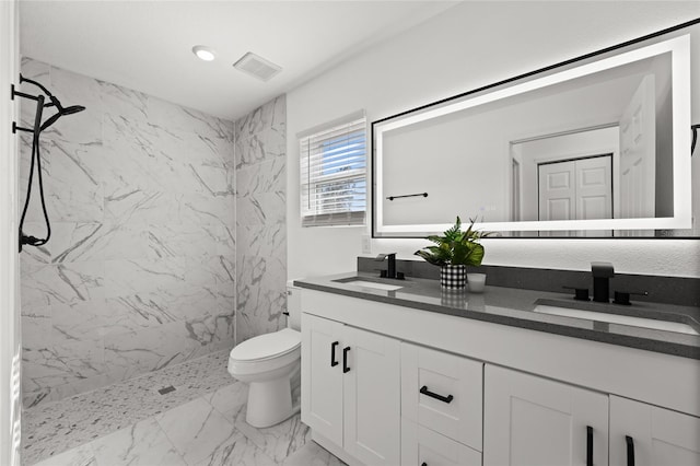 bathroom featuring vanity, toilet, and tiled shower