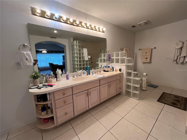 bathroom with tile patterned flooring, vanity, a shower, and a textured ceiling